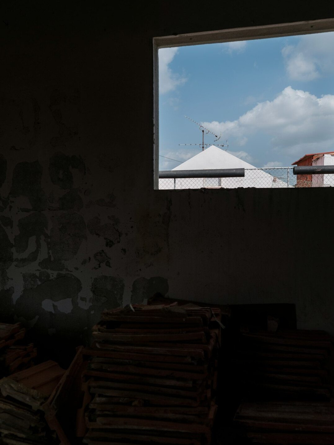 Old books stacked beside a window